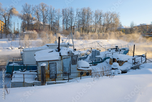 Two old boats in winter parking on February sunny morning. Vytegra, Russia