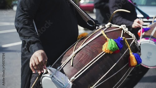 Indian man plays musical percussion instrument Dhol using wooden sticks. Traditional musical instrument Dhol