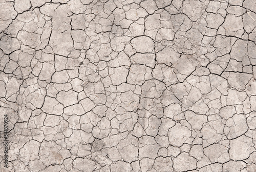 Surface of a grungy dry cracking parched earth for textural background.