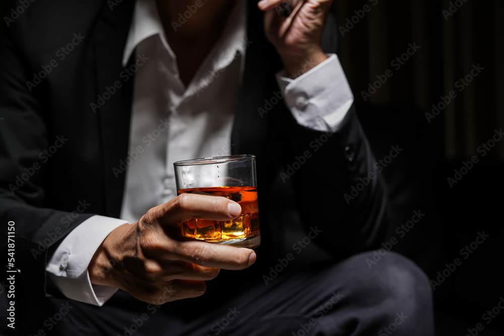 Closeup businessmen holding a glass of whiskey Closeup businessmen holding a glass of whiskey