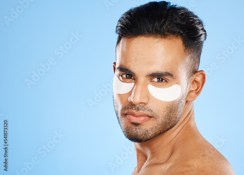 Skincare, eyes patch and man portrait of beauty product, body cosmetics and wellness, facial treatment and aesthetic health on studio blue background. Arab guy face portrait, hydration and self care