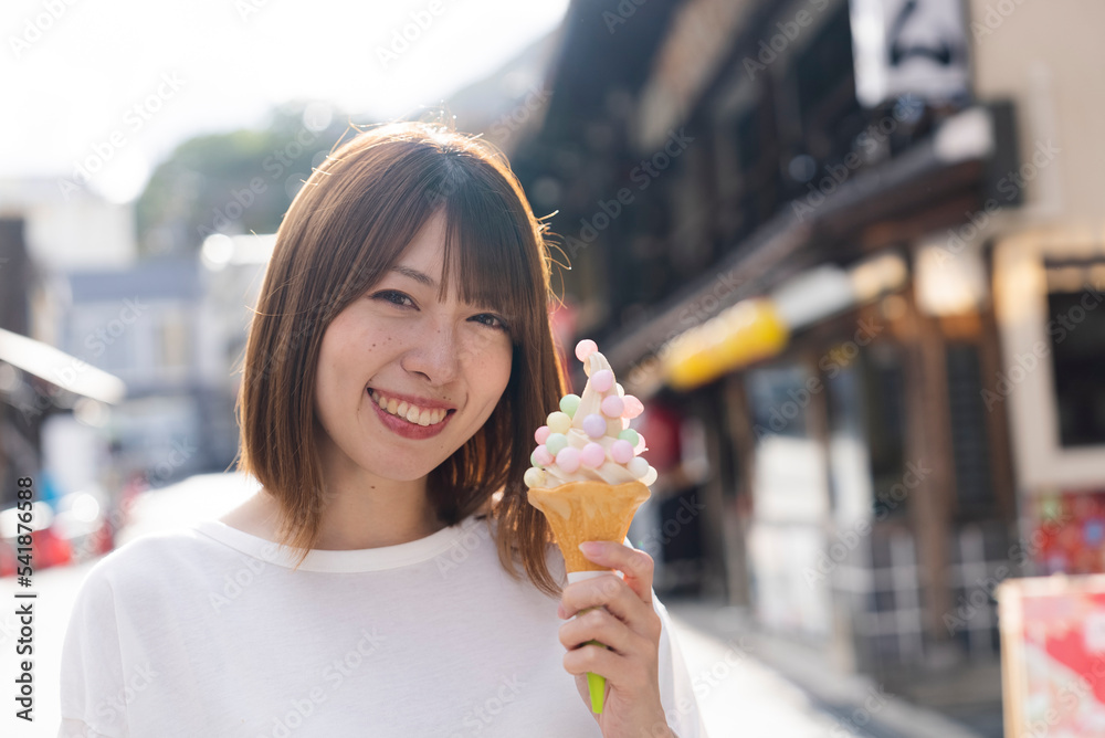 観光地でソフトクリームを食べる女性