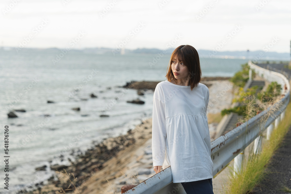 夕暮れの海岸線にいる女性 夕暮れの海岸線にいる女性