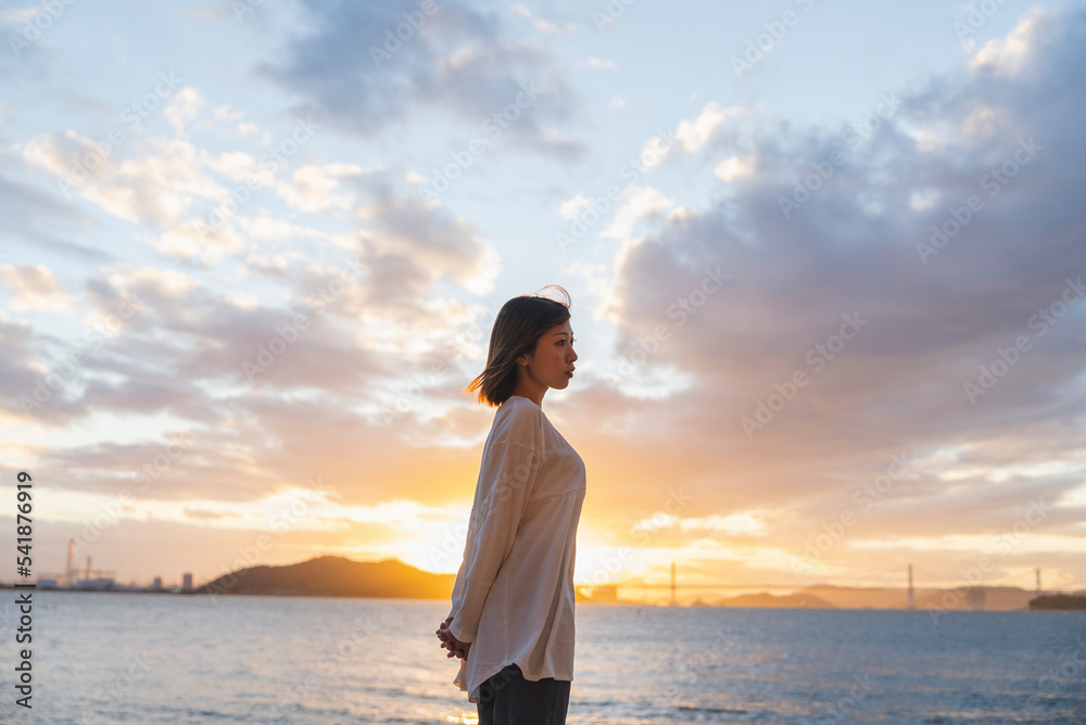 夕暮れの海にいる女性