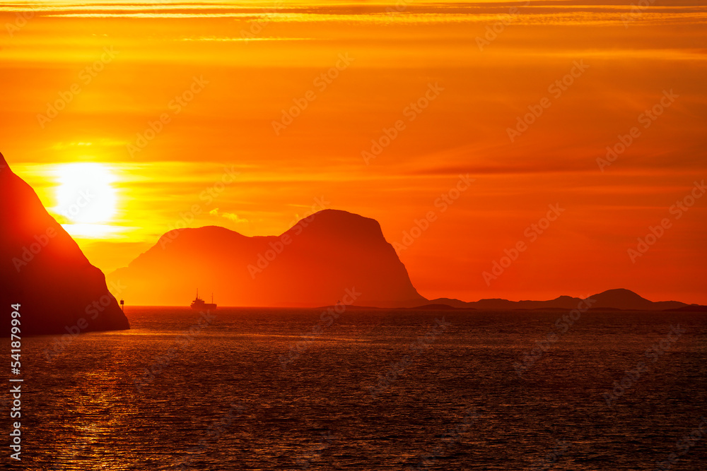 Rocky coastline at sunset with a fishing boat