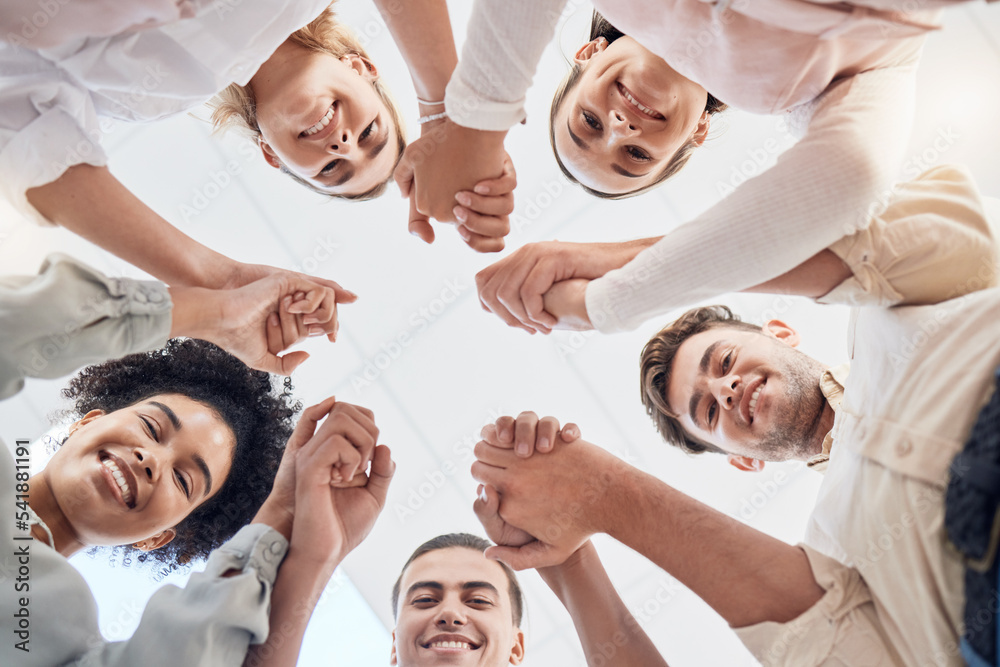 Fototapeta premium Teamwork, support and collaboration of happy employees with diversity, synergy and trust holding hands and looking down. Men and women team building circle for mental health mission in workplace
