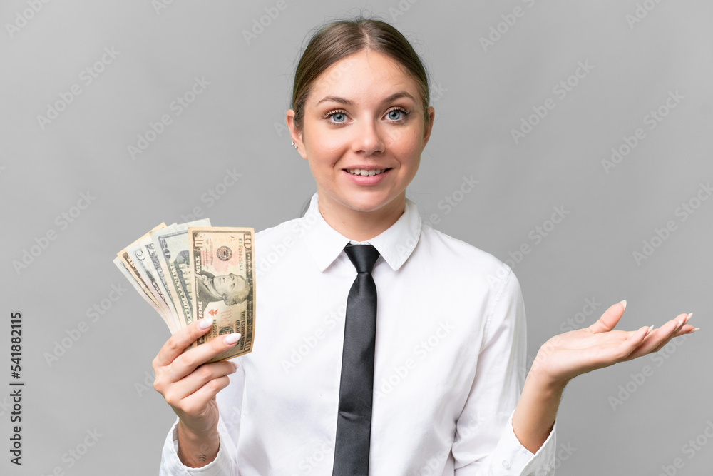 Young business caucasian woman holding money over isolated background with shocked facial expression Young business caucasian woman holding money over isolated background with shocked facial expression
