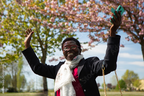 Happy African woman with smartphone in hand. Concept of freedom and emancipation photo