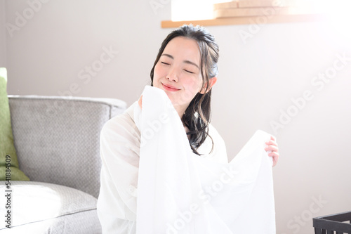 フワフワのタオルを顔に寄せる美しい女性 目を閉じる コピースペースアリ