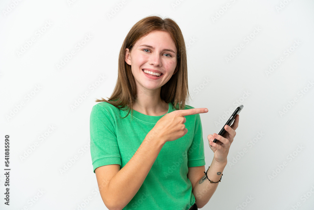 Young English woman isolated on white background using mobile phone and pointing it Young English woman isolated on white background using mobile phone and pointing it