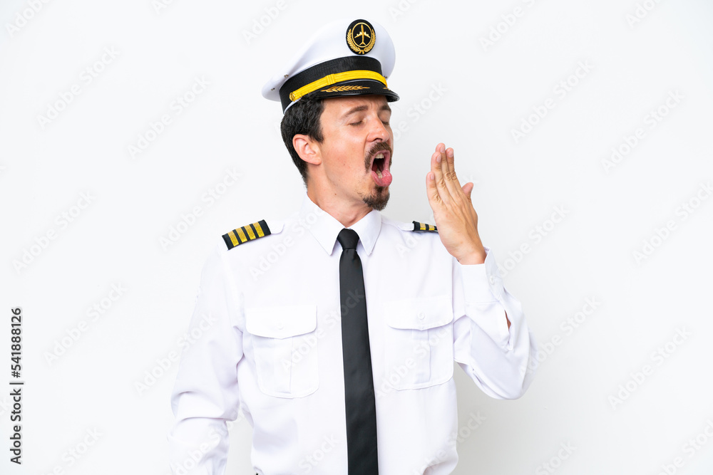 Airplane caucasian pilot isolated on white background yawning and covering wide open mouth with hand