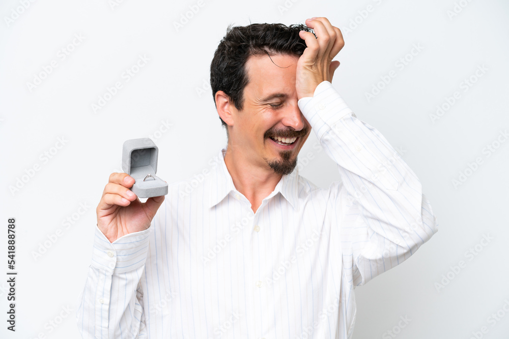 Young man holding a engagement ring isolated on white background has realized something and intending the solution Young man holding a engagement ring isolated on white background has realized something and intending the solution