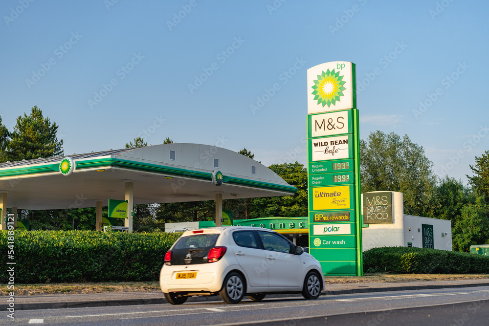 BP petrol station showing high UK fuel price sign and car in motion