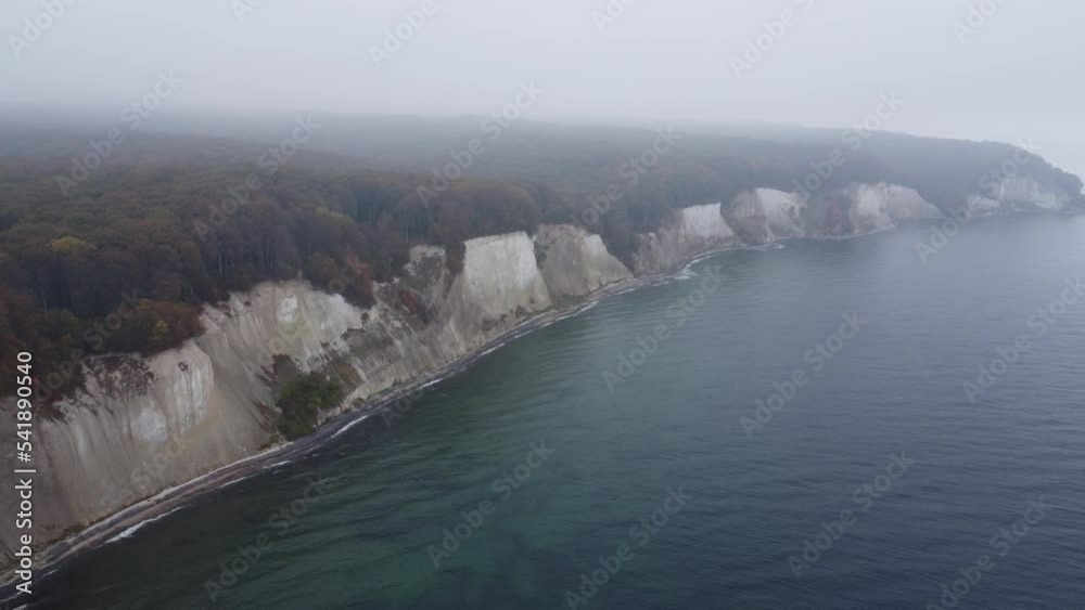 pan drone shot of the Jasmund national park cliffs with its UNESCO world heritage beech forests in misty October weather pan drone shot of the Jasmund national park cliffs with its UNESCO world heritage beech forests in misty October weather