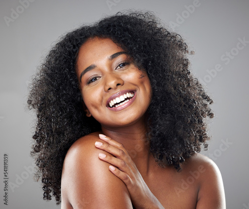 Face, beauty and skincare with a model black woman in studio on a gray background with a happy smile. Portrait, cosmetics and wellness with an attractive young female posing to promote a product