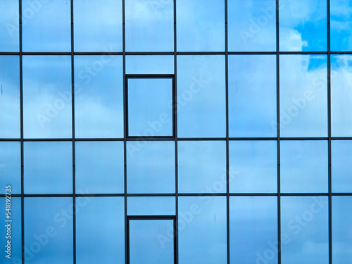 Mirrored windows of an office building. Reflection of clouds in the windows.
