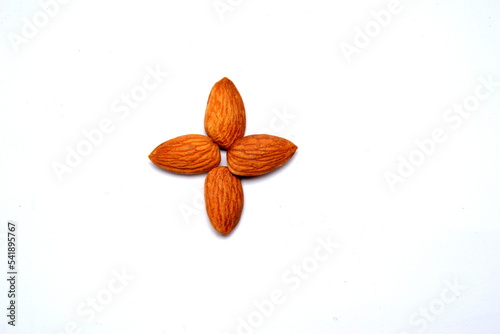 Fresh almonds in the wooden bowl, Organic almonds, almonds border white background, Almond nuts on a dark wooden background. Healthy snacks. Top view. Free space for text. photo