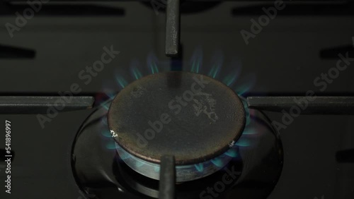 Kitchen burner gas stove with igniting fire. Gas stove burning blue flame.