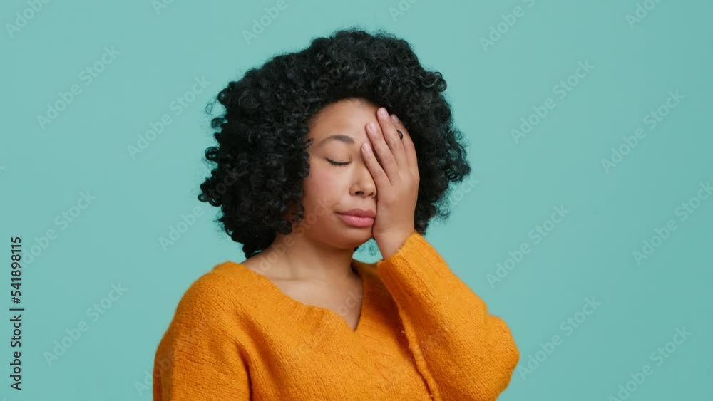 Upset worried curly hair woman slapping hand on face and expressing regret, blaming herself for troubles, feeling helpless studio. Facepalm, sorrow emotions on beautiful face of African American model Upset worried curly hair woman slapping hand on face and expressing regret, blaming herself for troubles, feeling helpless studio. Facepalm, sorrow emotions on beautiful face of African American model