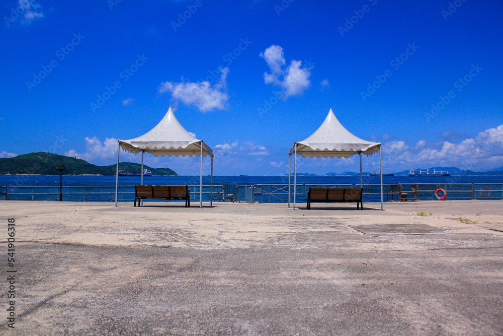 Benches with tent at the seashore under the blue sky