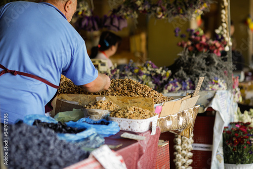 Shallow depth of field (selective focus) details with a farmer selling walnut kernels on a stand in Obor market in Bucharest, Romania. photo