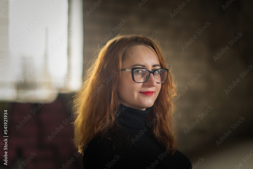 Portrait of a young beautiful red-haired girl in glasses in a low key. There is artistic noise. Portrait of a young beautiful red-haired girl in glasses in a low key. There is artistic noise.