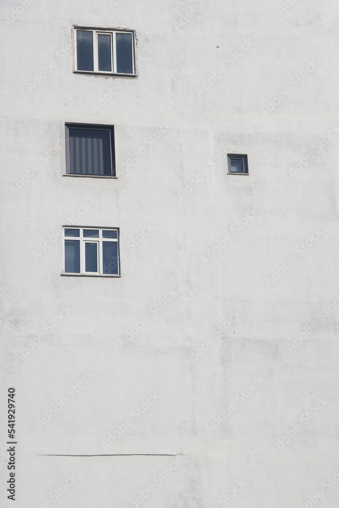 white facade of modern building with many black windows white facade of modern building with many black windows
