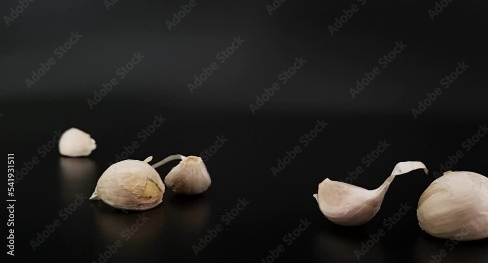 Garlic on a black background falls from above. Garlic on a black background falls from above.