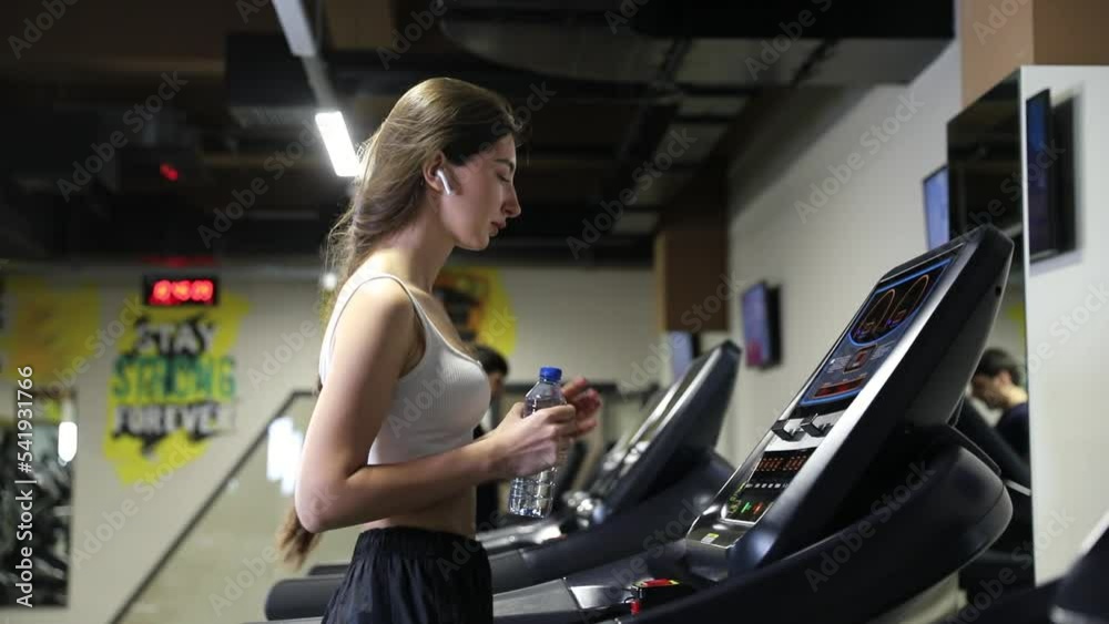 Healthcare, fitness and bodybuilding concept. A slender girl does a cardio workout on a treadmill in the gym. Running activity. Healthcare, fitness and bodybuilding concept. A slender girl does a cardio workout on a treadmill in the gym. Running activity.