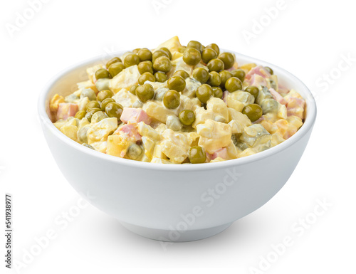 Olivier salad with vegetables and peas is isolated on a white background. Side view, close-up.