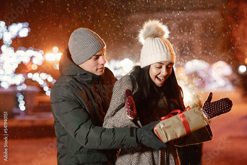 Young couple outdoor in night street at winter time