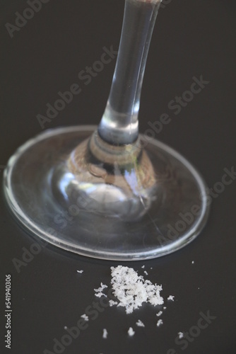 little pile of dried tartrate wine crystals next to the foot of a wineglass photo