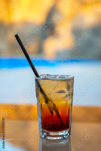 close-up shot of glass of cocktail on blurred beach background