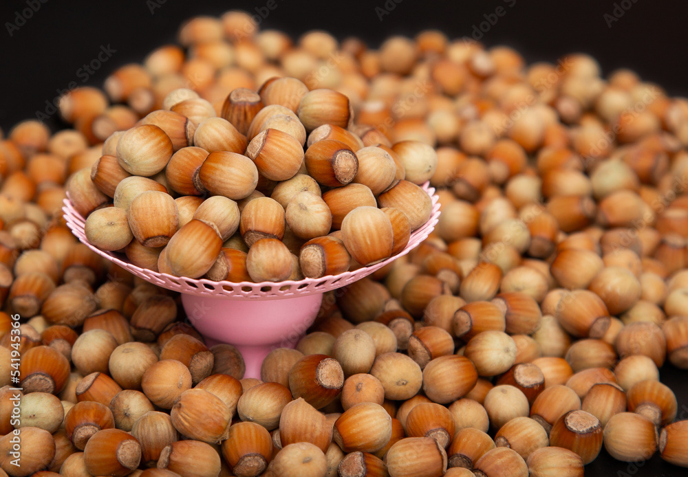 Many Hazelnuts on a pink stand are piled with a slide-Много Many Hazelnuts on a pink stand are piled with a slide-Много