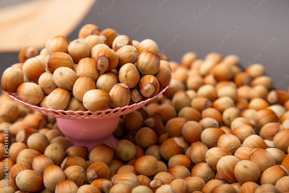 Many Hazelnuts on a pink stand are piled with a slide-Много Many Hazelnuts on a pink stand are piled with a slide-Много