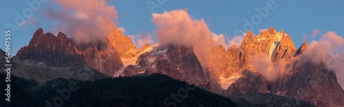 The panorama of  Les Aiguilles towers in sunset light - Grands Charmoz, Aiguille du Grepon, Aiguille de Blaitiere,  Aiguille du Plan. photo