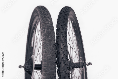 Old and new bicycle tires, comparison of an old tire with worn spikes and a new bicycle tire, the concept of timely replacement of tires for transport photo