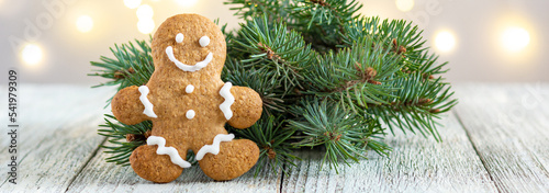 banner of Gingerbread man with fir tree branch on bokeh lights background