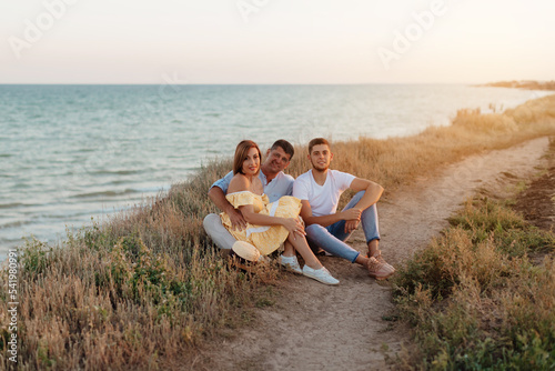 Happy middle-aged family with an adult son by the sea. Close-up photo.