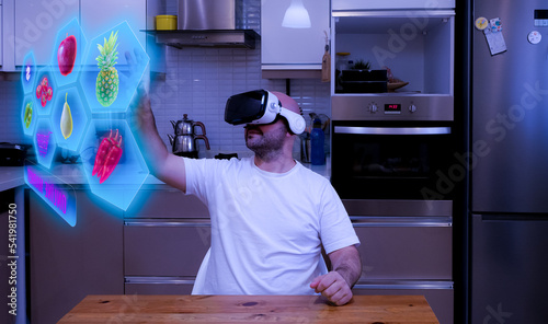 Young man sitting in the kitchen doing his market shopping from the virtual market. Virtual vegetable market in the metaverse universe. future market.