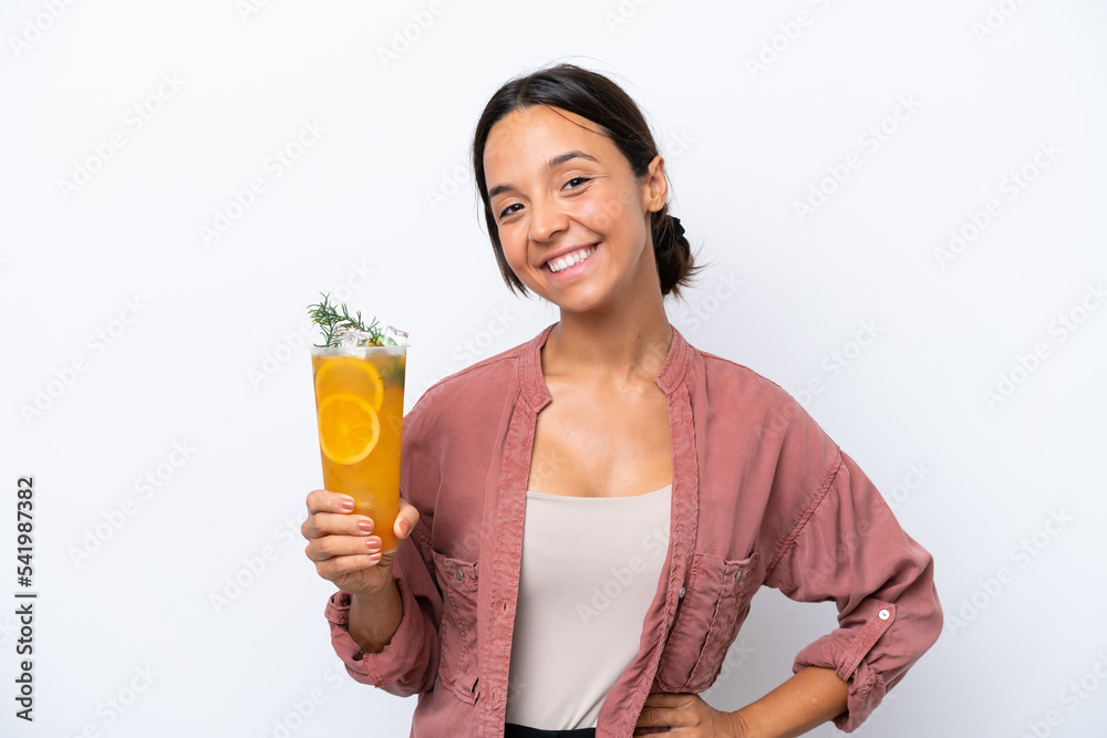 Young hispanic woman holding a cocktail isolated on white background posing with arms at hip and smiling Young hispanic woman holding a cocktail isolated on white background posing with arms at hip and smiling