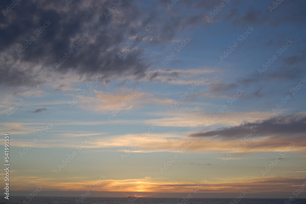 Beautiful sunset scenery on the Cantabrian sea and orange sky above it with stunning golden sun reflection on the calm waves as a background. Amazing view of summer sunset on the beach. Beautiful sunset scenery on the Cantabrian sea and orange sky above it with stunning golden sun reflection on the calm waves as a background. Amazing view of summer sunset on the beach.