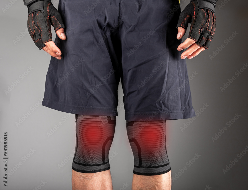 Knee pain, strain close up. Athlete wearing kneecap joint protection bandage, sleeve Stock Photo