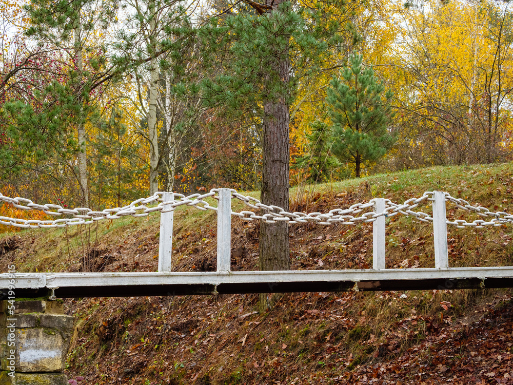 Iron bridge on a concrete footing over a dried-up lake in park Iron bridge on a concrete footing over a dried-up lake in park
