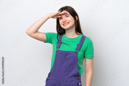 Young Russian woman isolated on blue background saluting with hand with happy expression
