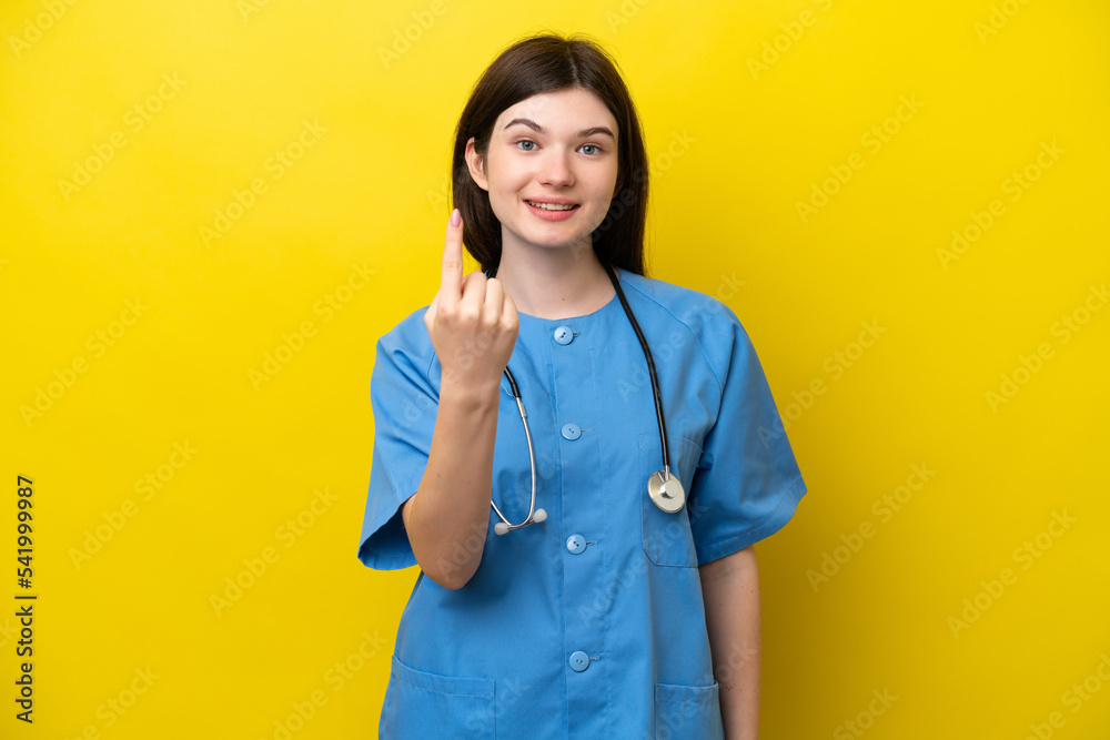 Young surgeon doctor Russian woman isolated on yellow background doing coming gesture Young surgeon doctor Russian woman isolated on yellow background doing coming gesture