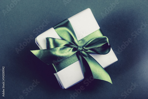Obraz na płótnie Gift box with green bow on dark background w salonie