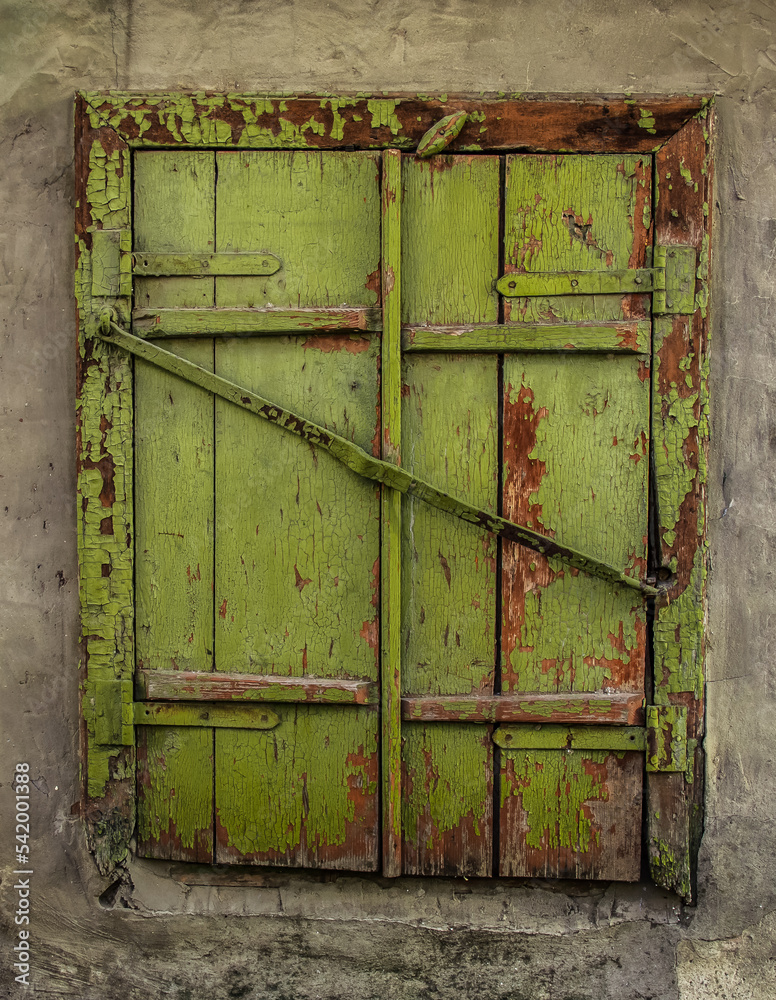 Old window with closed shutters.
