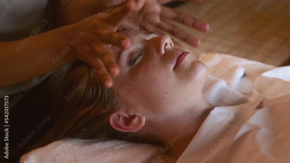 Woman with closed eyes lying in luxury spa salon for head massage Woman with closed eyes lying in luxury spa salon for head massage