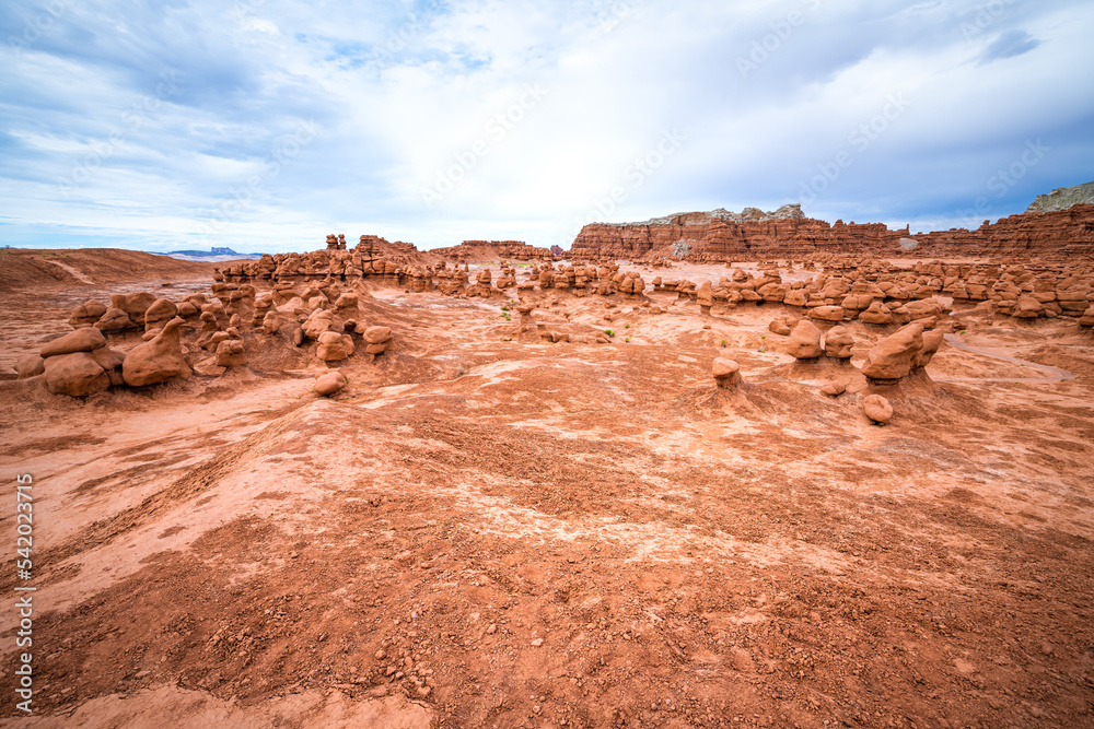 Wide angle view on hiking trail path at Goblin valley state park, Utah with nature desert valley landscape and hoodoo sandstone rock formations showing canyon erosion